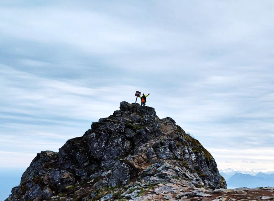 Op een bergtop met vlag — symbool voor avontuur en doorzettingsvermogen